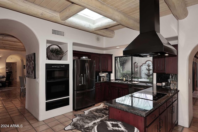 kitchen featuring black appliances, island range hood, dark brown cabinetry, dark stone countertops, and light tile patterned floors