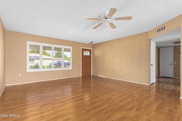 spare room with hardwood / wood-style flooring, ceiling fan, and a textured ceiling