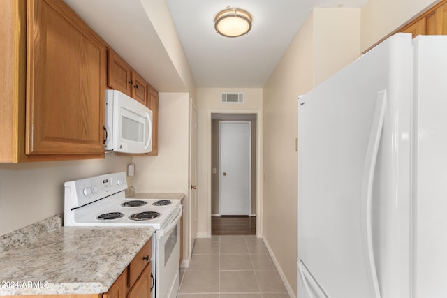 kitchen with light tile patterned floors and white appliances