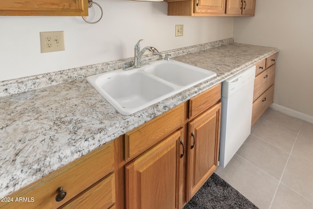 kitchen featuring white dishwasher, light tile patterned flooring, and sink