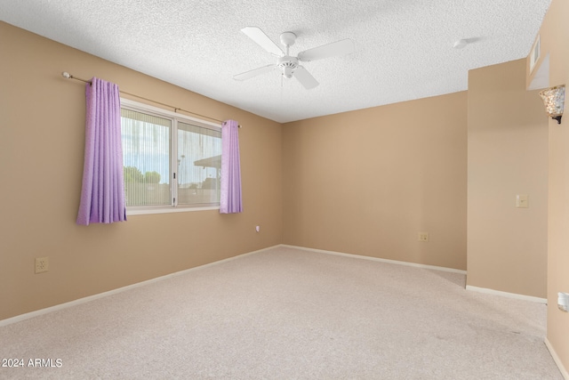 unfurnished room with ceiling fan, light colored carpet, and a textured ceiling