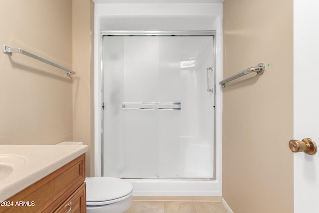 bathroom with toilet, vanity, tile patterned floors, and a shower with shower door