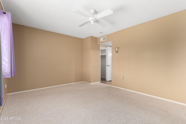 carpeted empty room featuring a textured ceiling and ceiling fan