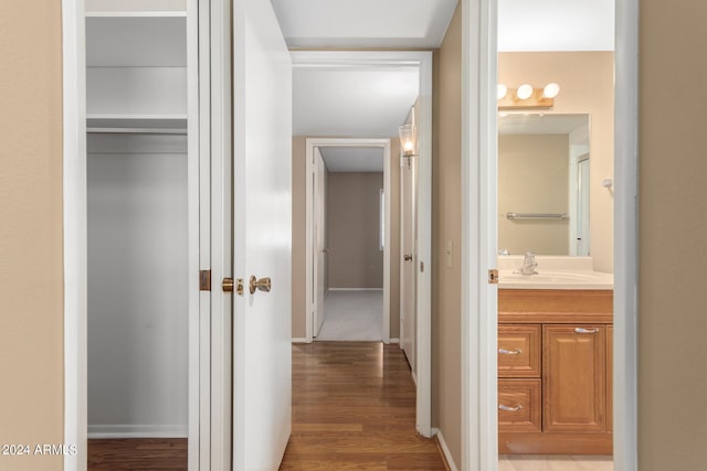 hallway with sink and wood-type flooring