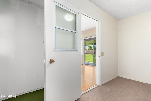 entryway with carpet floors and a textured ceiling