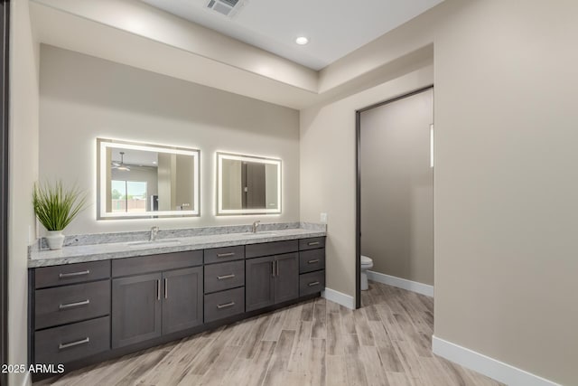 2516 W Joy Ranch Rd, Phoenix, AZ 85086 - bathroom with double vanity, wood finished floors, toilet, baseboards, and recessed lighting