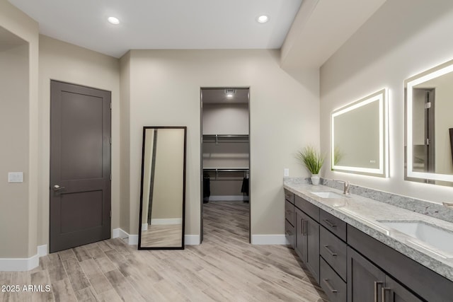 2516 W Joy Ranch Rd, Phoenix, AZ 85086 - bathroom featuring double vanity, wood finished floors, baseboards, recessed lighting, and a spacious closet