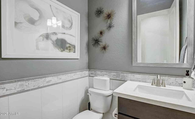 16336 W Jackson St, Goodyear, AZ 85338 - half bathroom featuring tile walls, vanity, and a wainscoted wall