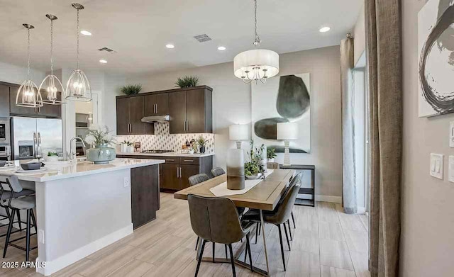16336 W Jackson St, Goodyear, AZ 85338 - kitchen featuring appliances with stainless steel finishes, a chandelier, dark brown cabinets, light countertops, and recessed lighting