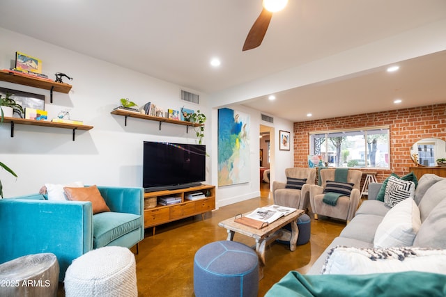 living room with ceiling fan, brick wall, and concrete floors