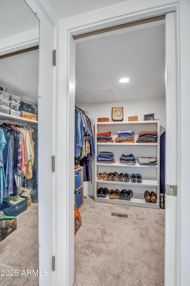 walk in closet featuring carpet floors and attic access