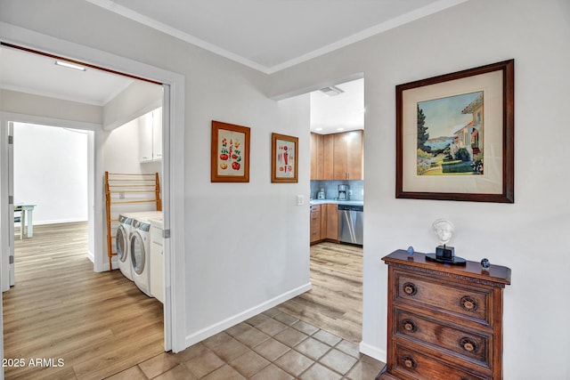 corridor featuring separate washer and dryer, crown molding, light wood-style floors, and baseboards