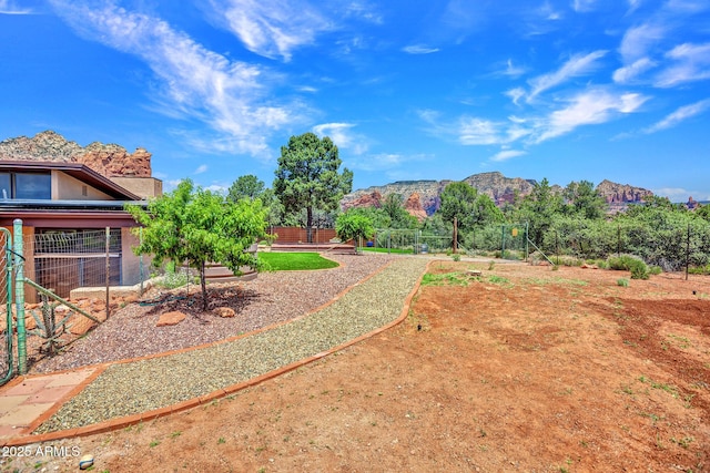 view of yard featuring a mountain view and fence
