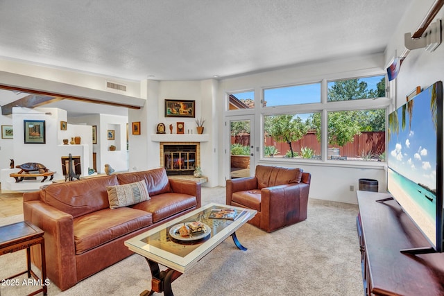 carpeted living area with a textured ceiling and a fireplace