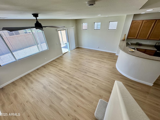 unfurnished living room featuring light wood finished floors and baseboards
