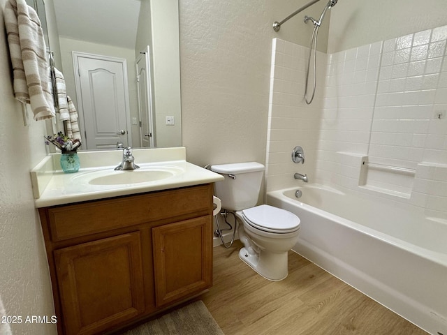 full bath featuring wood finished floors, a textured wall, toilet, and vanity