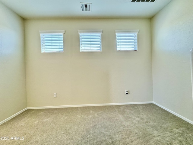 carpeted spare room with visible vents, baseboards, and a healthy amount of sunlight