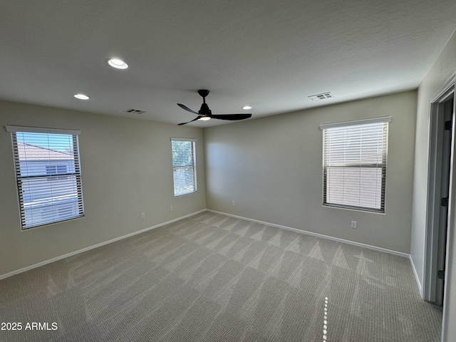 empty room featuring visible vents and light colored carpet