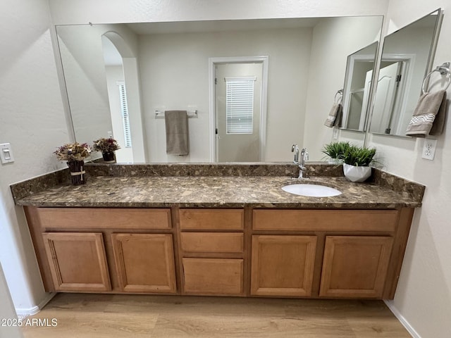bathroom featuring wood finished floors, vanity, and baseboards