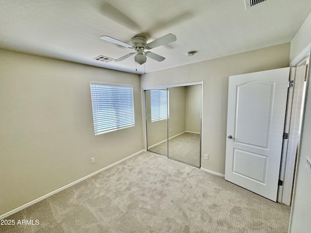 unfurnished bedroom with carpet flooring, a closet, a ceiling fan, visible vents, and baseboards