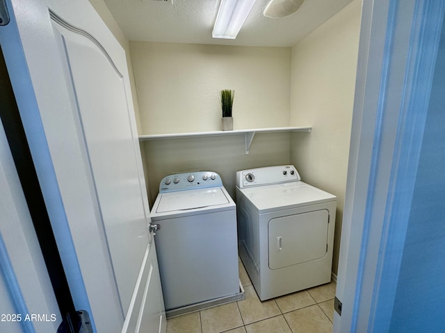 washroom with light tile patterned floors, independent washer and dryer, and laundry area