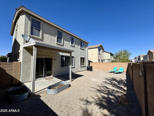 rear view of house featuring cooling unit, stucco siding, a fenced backyard, and a patio area