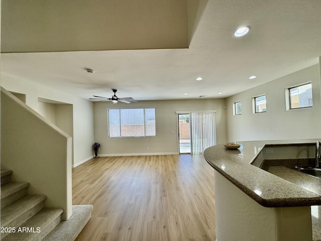 living room featuring recessed lighting, stairs, ceiling fan, baseboards, and light wood-type flooring