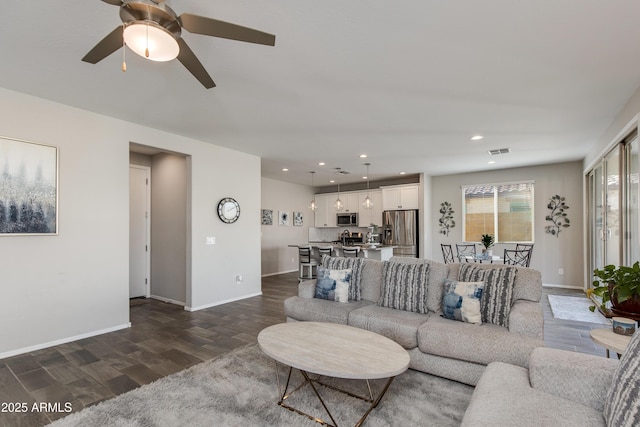 living room featuring ceiling fan and dark hardwood / wood-style flooring