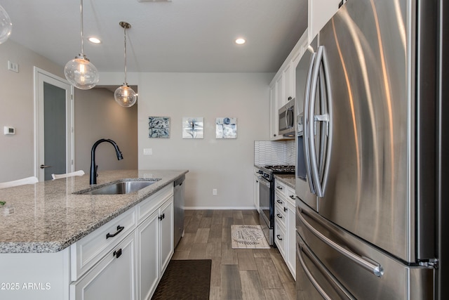 kitchen featuring an island with sink, stainless steel appliances, sink, and white cabinets