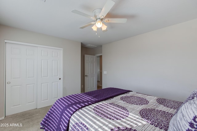 bedroom with ceiling fan, a closet, and light carpet