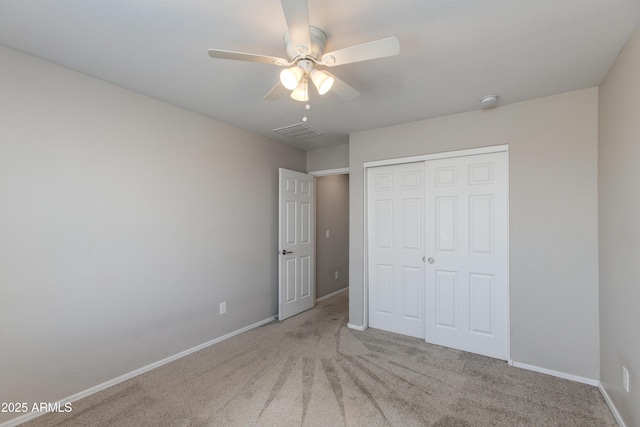 unfurnished bedroom with ceiling fan, a closet, and light carpet