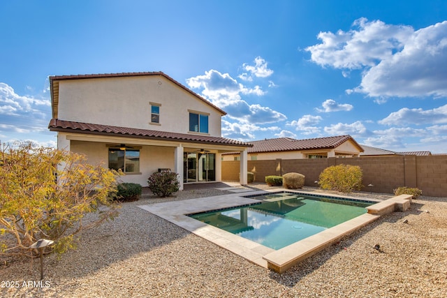 rear view of house featuring ceiling fan, a fenced in pool, and a patio