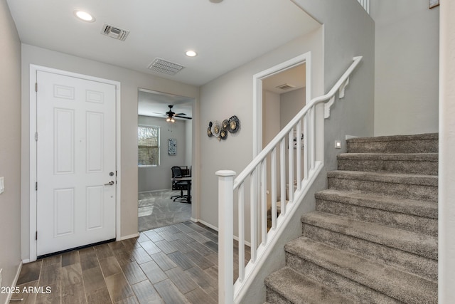 foyer entrance with ceiling fan and dark hardwood / wood-style flooring