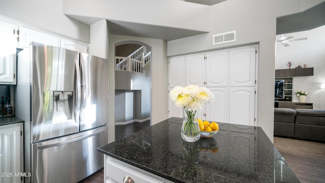 kitchen featuring white cabinetry, dark hardwood / wood-style floors, dark stone counters, and stainless steel fridge with ice dispenser