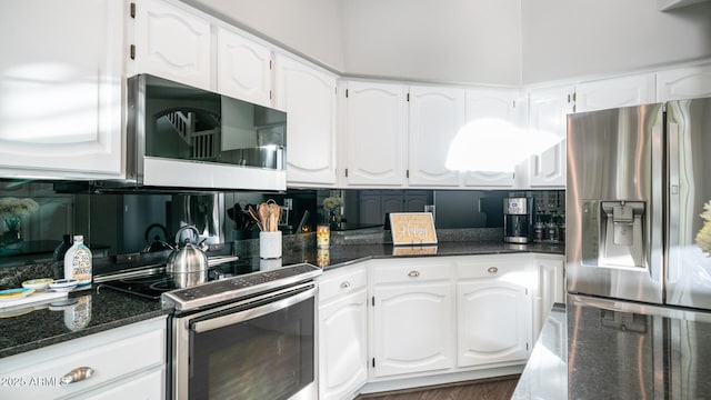 kitchen with dark stone countertops, appliances with stainless steel finishes, and white cabinets