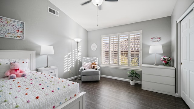 bedroom with lofted ceiling, dark wood-type flooring, ceiling fan, and a closet