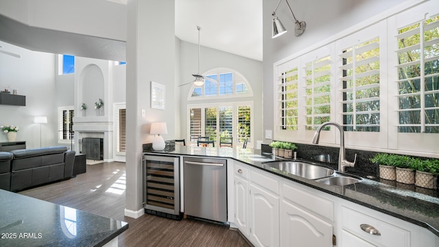 kitchen featuring white cabinetry, dishwasher, sink, and dark stone countertops