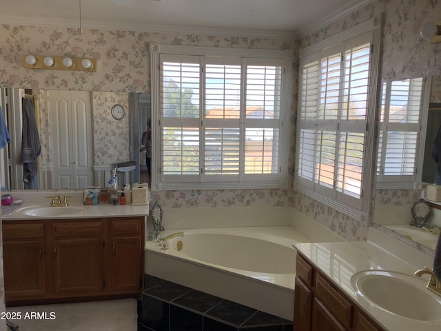 bathroom featuring a bath, wallpapered walls, two vanities, and a sink