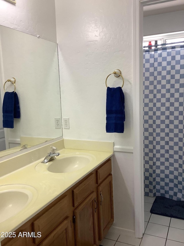 bathroom with curtained shower, a sink, and tile patterned floors