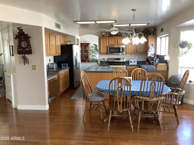 kitchen featuring a sink, visible vents, appliances with stainless steel finishes, dark countertops, and an inviting chandelier