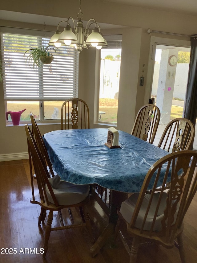 dining room featuring an inviting chandelier, baseboards, and wood finished floors