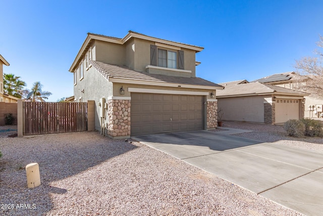 traditional-style home featuring a garage, fence, stone siding, driveway, and stucco siding