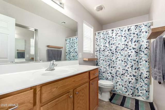 bathroom featuring visible vents, vanity, toilet, and a healthy amount of sunlight