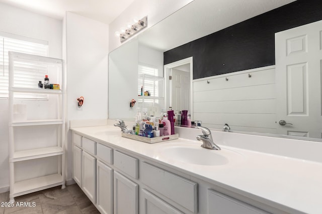 bathroom with double vanity, a closet, and a sink