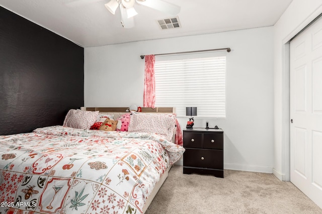 bedroom featuring baseboards, visible vents, ceiling fan, and light colored carpet