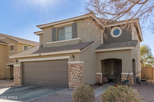 view of front of property with stone siding, a tiled roof, concrete driveway, and stucco siding