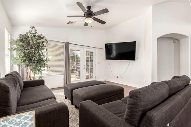 living area with visible vents, arched walkways, ceiling fan, wood finished floors, and french doors