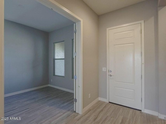 foyer with baseboards and light wood finished floors