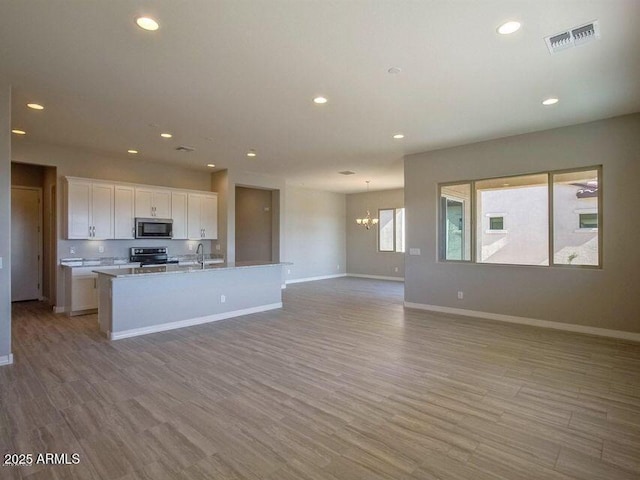 kitchen featuring white cabinets, recessed lighting, open floor plan, and stainless steel appliances