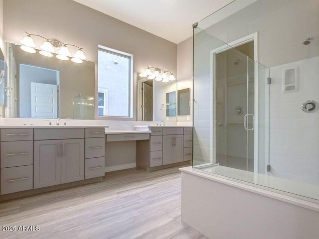 full bathroom featuring a stall shower, two vanities, and a sink